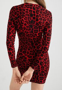 Czerwono-czarna sukienka dopasowana w panterkę z długimi rękawami, żebrowaną teksturą, obcisłym krojem i długości midi.