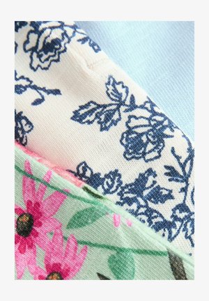 Tři vzorky látek: krémová s námořnickým květinovým vzorem, světle modrá a světle zelená s růžovými květy a zelenými listy, ukazující různé textury.