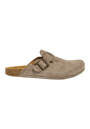 Zapato de ante beige tipo mocasín con punta redonda, que presenta una sola correa ajustable con hebilla y una plantilla de corcho. Suela plana y texturizada.