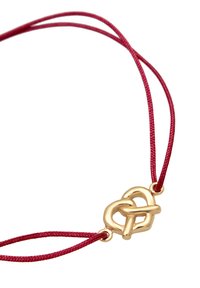 Röd flätad snöre halsband med en pendel av guldmetall i mitten, som reflekterar ljus med en slät, glänsande yta.