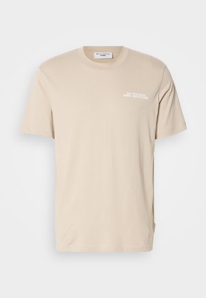 T-shirt de algodão bege com mangas curtas, gola redonda e uma gráfica impressa que diz "A TUA AVENTURA" no peito. Design minimalista.