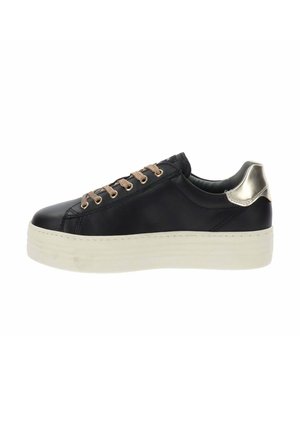 Sneaker bas noir avec lacets beige, semelle blanche épaisse et détail métallique argenté sur le talon, vu de côté.