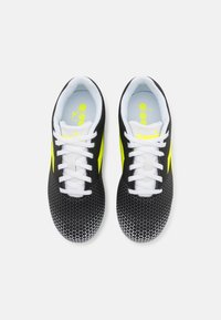Scarpe sportive nere con una parte superiore testurizzata, lacci bianchi, dettagli in giallo brillante e un motivo geometrico nella zona delle punte.