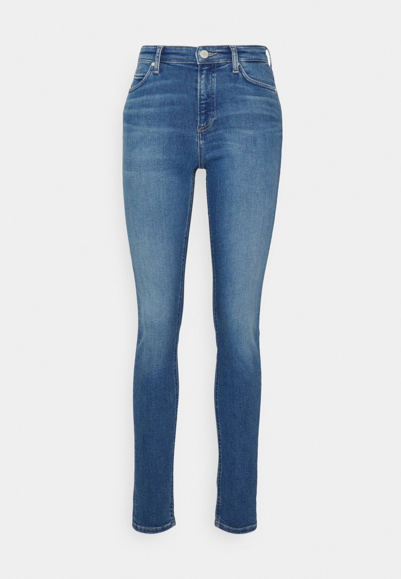 Jeans ajustados en denim azul medio. Diseño de cintura alta con una textura suave, bolsillos delanteros y traseros discretos, y detalles de desgaste sutiles.