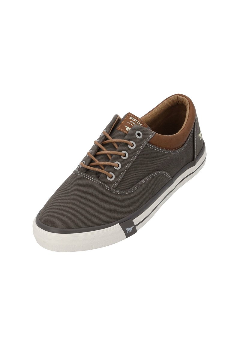 Zapatillas de lona gris con detalles de cuero marrón, punta redonda y suela de goma blanca. Presentan cordones y un logo en el lateral. Superficie texturizada.