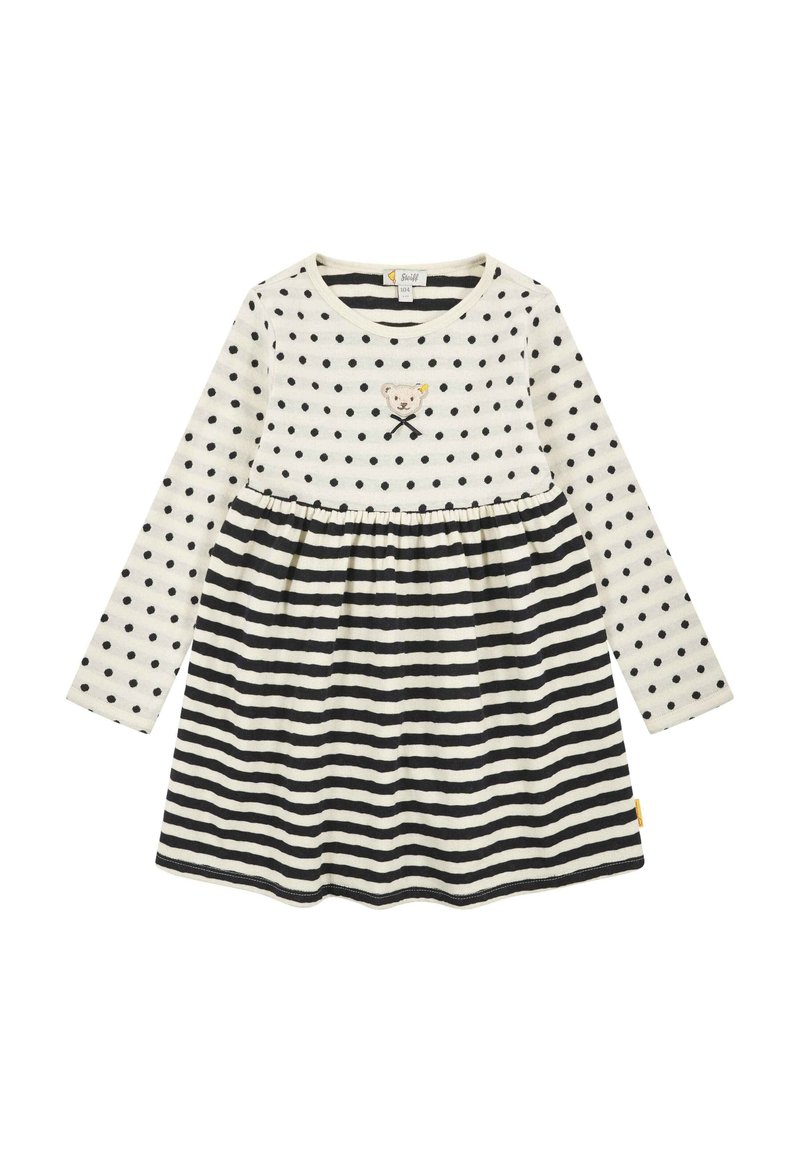 Abito a maniche lunghe color crema con pois neri e gonna a righe. Presenta un orlo curvo, un design di un orsetto ricamato e una vita arricciata.