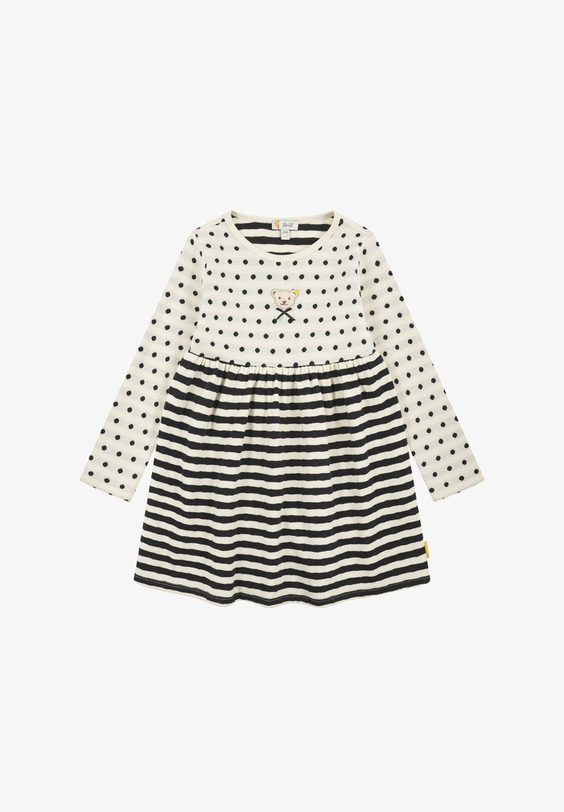 Abito a maniche lunghe color crema con pois neri e gonna a righe. Presenta un orlo curvo, un design di un orsetto ricamato e una vita arricciata.