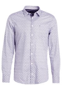 Dlouhý rukáv košile světle fialové barvy s geometrickým vzorem. Obsahuje límec s knoflíky a přední panel s bílými knoflíky.