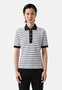 Pruhovaná polokošile v černé a bílé barvě s černým límcem, tříknoflíkovou légou, krátkými rukávy a slim fit střihem. Materiál se zdá být texturovaný.