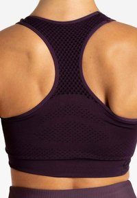 Lila Sport-BH mit Mesh-Details, einem Racerback-Design und strukturierten Akzenten, die eine enganliegende Passform und Atmungsaktivität für aktive Kleidung bieten.