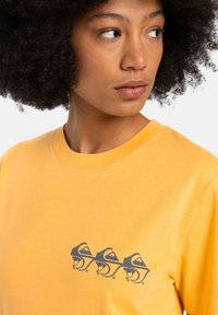 Yellow cotton t-shirt with a crew neck, featuring a black graphic design on the chest of stylized mountain silhouettes and waves.