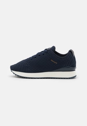 Zapatilla de deporte azul marino tejida con suela blanca, cordones en la parte delantera y logotipo de GANT en el lateral, vista desde el lado exterior.
