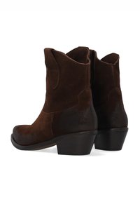 Brązowe zamszowe kowbojskie buty z lekko zakrzywionym noskiem, krótkimi bokami i ciemnobrązowym obcasem. Teksturowana powierzchnia z kontrastującymi tonalnymi sekcjami.