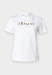 Vit bomulls-t-shirt med korta ärmar, med "ARMANI" och "EXCHANGE" i guldfärgade detaljer över bröstet.