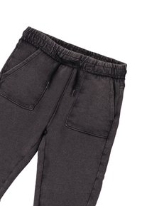 Pantalons de survêtement gris foncé avec une taille élastique, cordon de serrage noir et grandes poches à rabat sur le devant des deux côtés.