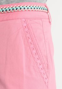 Rosa shorts i bomull med en texturerad sidoficka och flätad detalj i mintgrön och marinblå vid midjan.