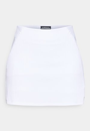 Mini saia branca canelada com corte reto, apresentando dois fechos de lado e um rótulo de marca na cintura. Textura suave.