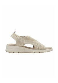 Beige kötött szandál, nyitott orral, kivágott oldalakkal és texturált mintázattal ellátott wedges talppal a tapadás és a támogatás érdekében.