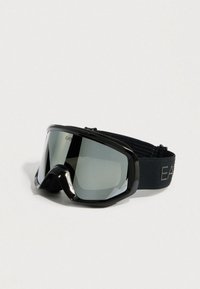 Fekete síszemüveg széles lencsével és puha habszivacs kerettel. Vastag, állítható pánttal rendelkezik, melyen "EA" logó található. A tükröződő lencsék visszaverik a fényt.