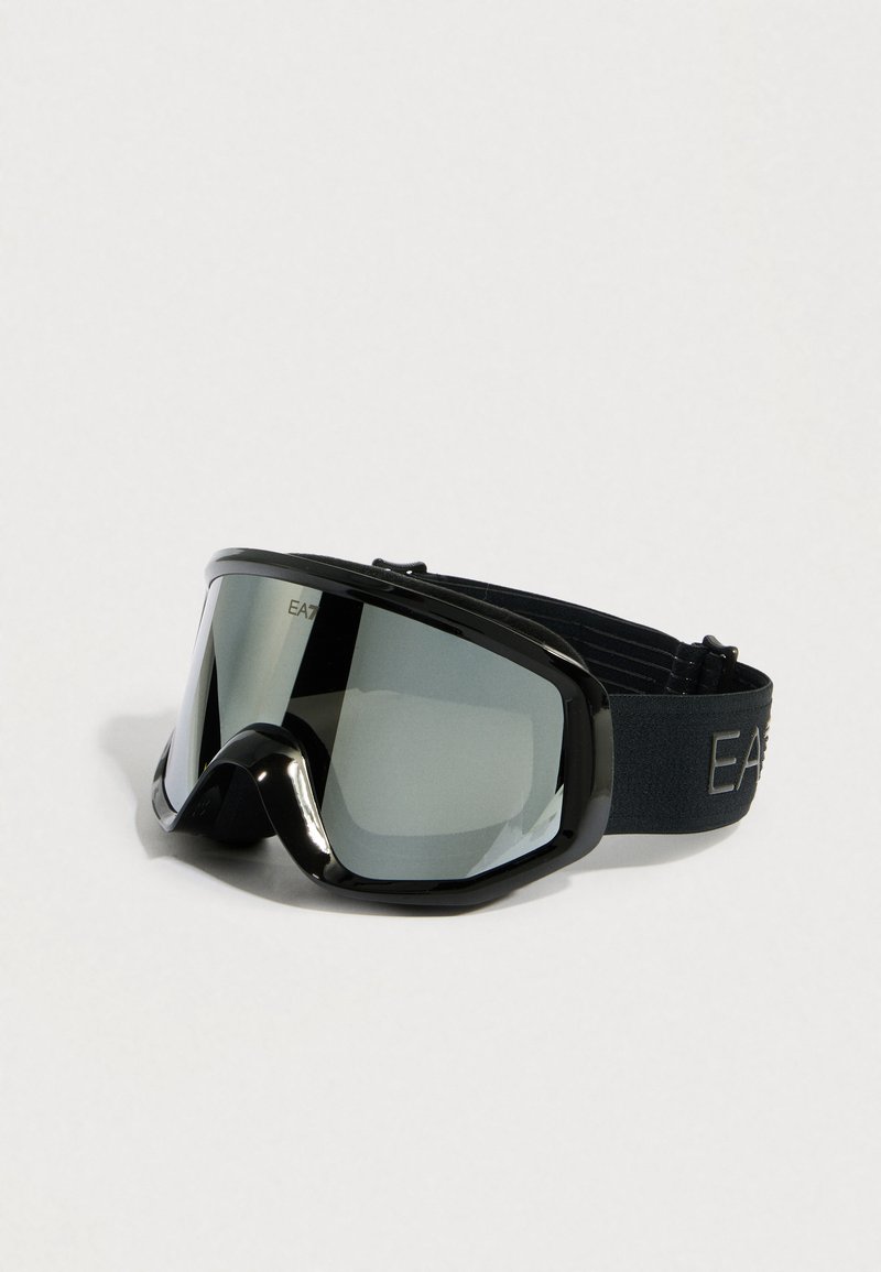 Fekete síszemüveg széles lencsével és puha habszivacs kerettel. Vastag, állítható pánttal rendelkezik, melyen "EA" logó található. A tükröződő lencsék visszaverik a fényt.