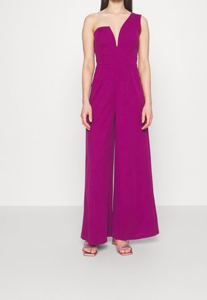Eén-schouder jumpsuit met diepe V-hals in levendig fuchsia. Kenmerkt zich door een wijd been ontwerp en zachte stof. Aangekleed met minimalistische bandjes.