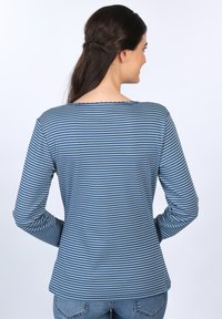 Langärmliges gestreiftes Hemd in Blau und Grau, mit einem Bootsausschnitt und einem gewellten Saum, von hinten sichtbar. Weicher, dehnbarer Stoff.