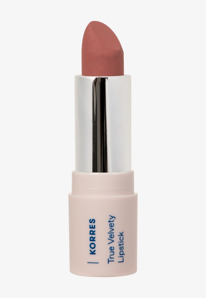 Rouge à lèvres dans une teinte rose doux avec un tube argenté et une base rose pâle étiquetée "Korres True Velvety Lipstick" sur un fond blanc.