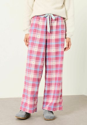 Lockere rosa karierte Hose mit kleinen Herzmustern, geschnürter Taille, getragen mit grauen Hausschuhen und einem cremefarbenen Pullover.