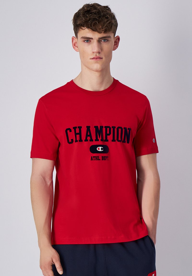 Rode katoenen T-shirt met korte mouwen, een ronde hals en een opvallend marineblauw Champion-logo en tekst over de borst.