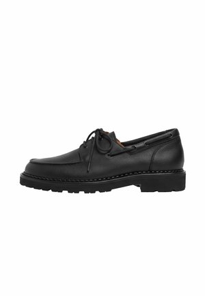 Chaussure bateau en cuir noir avec laçage à l'avant, semelle cousue et semelle extérieure épaisse en caoutchouc cranté, vue de profil.