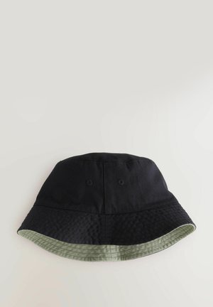 Black bucket hat with a textured surface and a green, patterned underside. Features two eyelets for ventilation.