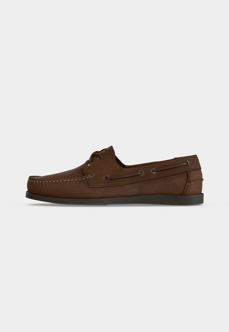 Καφέ δερμάτινο μοκασίνι σε στιλ loafers με λεπτομέρειες από κορδόνια και χαμηλή μαύρη σόλα, εμφανίζεται από το πλάι σε απλό λευκό φόντο.