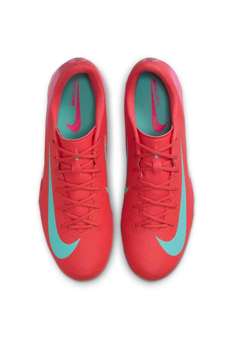 Des chaussures de sport synthétiques rouges avec une texture lisse, arborant des accents et des lacets turquoise, ainsi qu'un logo Nike distinct sur le côté.