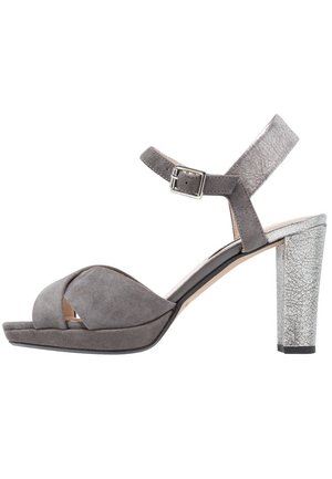 Sandal de ante gris con apertura en la punta, tiras cruzadas anchas y correa ajustable en el tobillo; tacón alto de textura agrietada metálica plateada.