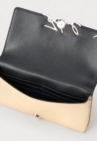 Käev�õru rahakott musta nahkinterjööriga ja beeži nahkvälispinnaga. Omab hõbedaste detailide ja sileda tekstuuri.