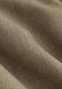 Material ribbed de culoare maro, cu o textură moale, având variații subtile de culoare și detalii fine de cusătură pe margini.