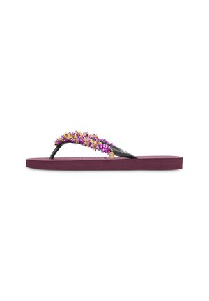 Sandale plate violette type tongs avec des lanières noires décorées de perles florales violettes et dorées et un petit pendentif doré.