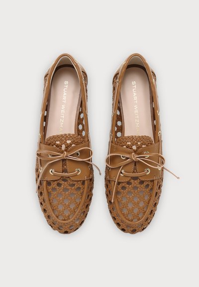 Mocassins tressés en cuir marron avec lacets, de la marque Stuart Weitzman, présentés côte à côte sur un fond clair.