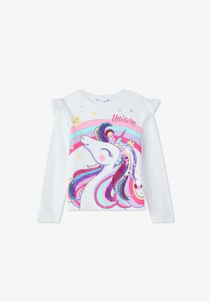 Biała bluzka z długim rękawem z grafiką jednorożca z wielokolorową, błyszczącą grzywą i falbaniastymi akcentami na ramionach. Tekst brzmi "Jednorożec."