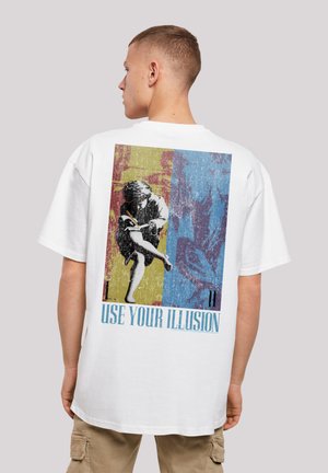 Weißes T-Shirt mit einem bunten Grafikdruck auf der Rückseite, der strukturierte Bilder und den Text "USE YOUR ILLUSION" in blauer Schrift zeigt.