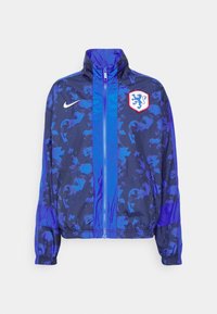 Nike vindjacka i blått med ett geometriskt mönster, hel dragkedja framtill, hög krage, elastiska ärmslut och ett emblemlogo.