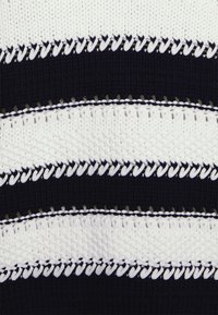 Sweter dziergany z naprzemiennymi poziomymi paskami w kolorze granatowym i białym, z teksturowanymi wzorami i kontrastowymi detalami przeszyć.