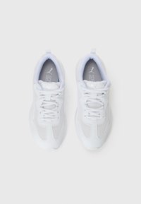 Een paar witte Puma sportschoenen met veters, net en leren details, vanuit een bovenaanzicht op een effen witte achtergrond.