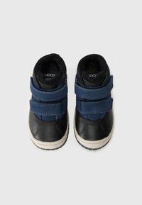 Zwarte en marineblauwe hoge sneakers met twee klittenbandstraps, gemaakt van leer en suède, met een gewatteerde enkel en een textuur rubberen zool.