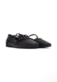 Ballerine in pelle nera con punta affusolata, caratterizzate da più cinturini neri decorati con perline argentate sulla parte superiore del piede.