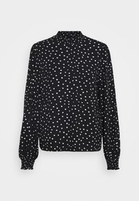 Blusa nera con pois bianchi, collo alto, maniche lunghe, polsini arricciati e vestibilità morbida. Realizzata in tessuto leggero.