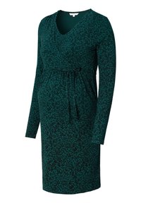 Długa sukienka ciążowa na zakładkę z długim rękawem w ciemnozielonym kolorze z czarnym wzorem liści. Posiada wiązanie w talii, dekolt w serek oraz miękką tkaninę.