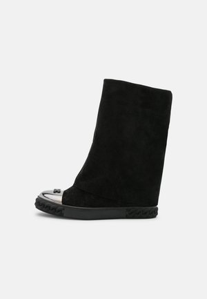 Botines de ante negro con punta plateada brillante, entresuela tejida texturizada y un diseño elegante de caña alta.