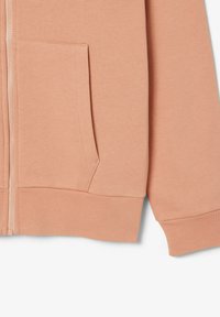 Sudadera con cremallera de color melocotón, con un bolsillo delantero y puños de canalé. La tela parece suave con una textura lisa, diseñada para un uso casual.