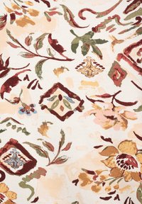Bloemtextiel met een crème achtergrond, gekenmerkt door multicolore bladeren en bloemen in rood, groen, goud en blauw, met patronen van diamanten en krullen.